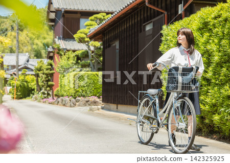 國中和高中女生推著自行車上下學。 142325925