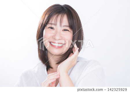 一位擁有漂亮牙齒和亮澤秀發的年輕女子，正展現著她的笑容。 142325929