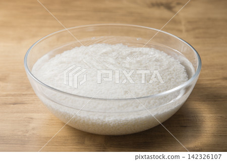 White rice soaked in water; washing and soaking the rice before cooking. White rice soaked in water; washing and soaking the rice before cooking. 142326107