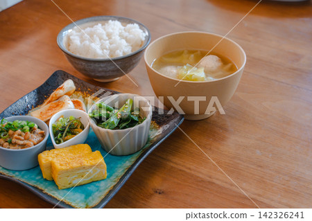 日式早餐擺放在木桌上,食材擺放均衡。 日式早餐擺放在木桌上,食材擺放均衡。 142326241