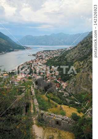The view of Kotor's city walls zigzagging down the mountainside, a spectacular view of the Bay of Kotor in Montenegro. The view of Kotor's city walls zigzagging down the mountainside, a spectacular view of the Bay of Kotor in Montenegro. 142326923