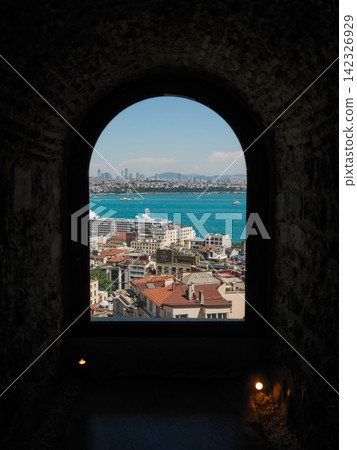 A view of the Golden Horn and cruise ships through the stone arch windows of Istanbul, along with the cityscape of the old city. A view of the Golden Horn and cruise ships through the stone arch windows of Istanbul, along with the cityscape of the old city. 142326929