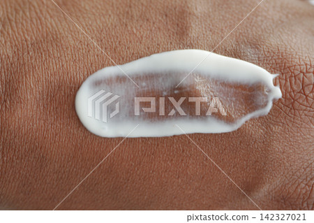 Applying cream to hand in natural light Applying cream to hand in natural light 142327021