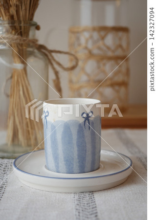 Coffee cup on a table with decorations and plants 142327094