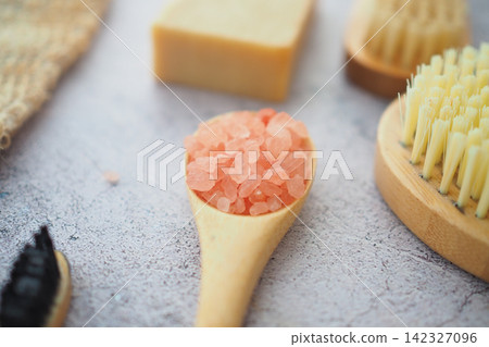 Salt in wooden spoon with natural spa products 142327096