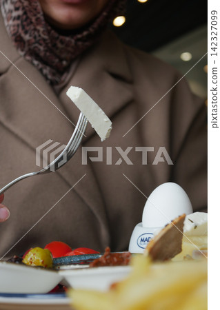 Enjoying a meal with bread and cheese in a cafe Enjoying a meal with bread and cheese in a cafe 142327099