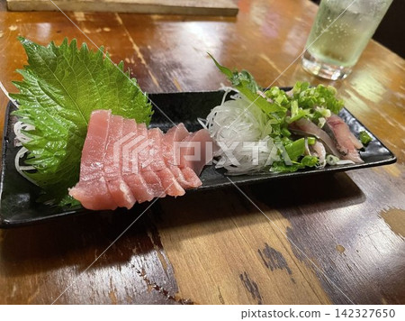 A platter of tuna and blue fish sashimi to enjoy at an izakaya (Japanese pub). A platter of tuna and blue fish sashimi to enjoy at an izakaya (Japanese pub). 142327650