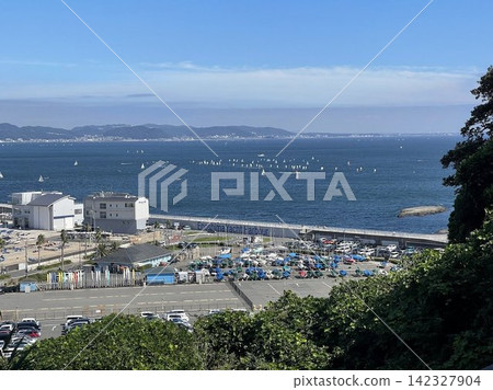 A sunny day at Enoshima Yacht Harbor and sailing boats floating in Sagami Bay. A sunny day at Enoshima Yacht Harbor and sailing boats floating in Sagami Bay. 142327904