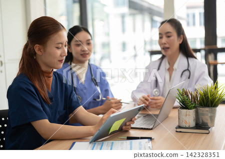 Healthcare professionals collaborating on patient care and medical information with digital devices Healthcare professionals collaborating on patient care and medical information with digital devices 142328351