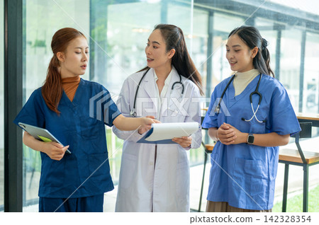 Doctors and nurses discussing medical records and patient care at a healthcare meeting Doctors and nurses discussing medical records and patient care at a healthcare meeting 142328354