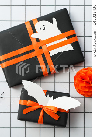 Halloween background. Presents wrapped in black paper with Halloween-themed decorations Halloween background. Presents wrapped in black paper with Halloween-themed decorations 142328430