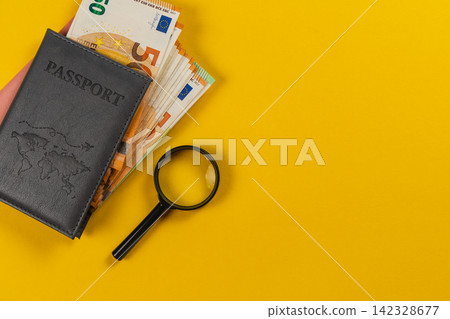 Planning travel expenses with passport and cash on yellow background Planning travel expenses with passport and cash on yellow background 142328677