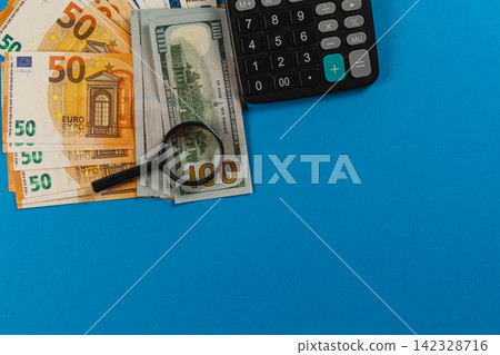 Tools used for financial analysis on a blue desk Tools used for financial analysis on a blue desk 142328716