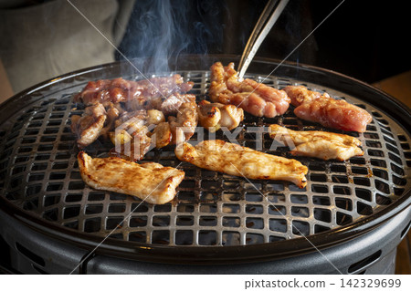 Grilled beef cooked over a charcoal grill, a scene of a meal with a fragrant finish from charcoal cooking. Grilled beef cooked over a charcoal grill, a scene of a meal with a fragrant finish from charcoal cooking. 142329699