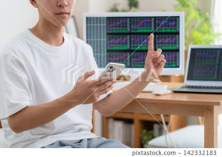 一位年輕人在家投資股票。 142332183