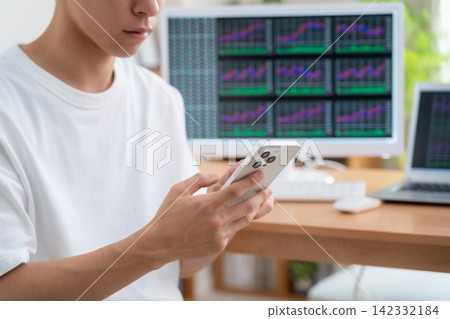 一位年輕人在家投資股票。 142332184