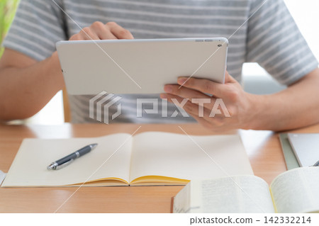 Young man studying at home Young man studying at home 142332214