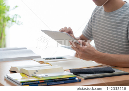Young man studying at home Young man studying at home 142332216