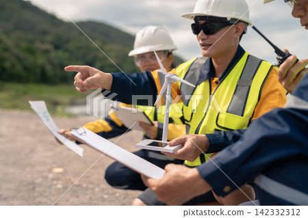 Architect team working with blueprints for sketching a construction project, green energy and solar panel concept. 142332312