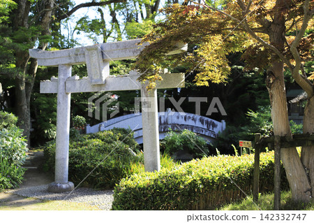 A stone torii gate in the temple garden; the plaque in the center is inscribed with the name Benzaiten. 142332747