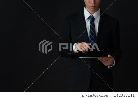 年輕的商人，背景是黑色的。 142333111