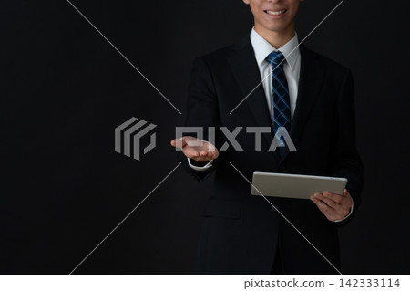 年輕的商人，背景是黑色的。 142333114