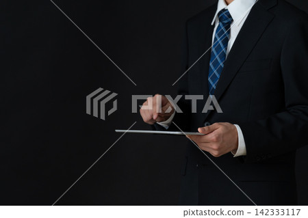 年輕的商人，背景是黑色的。 142333117