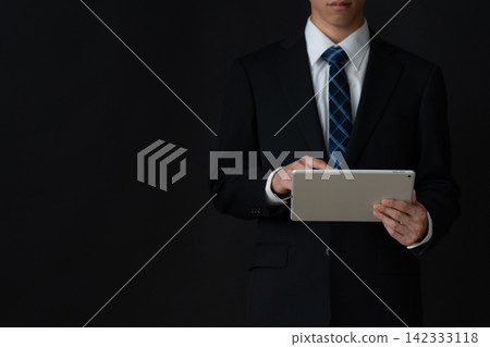 年輕的商人，背景是黑色的。 142333118