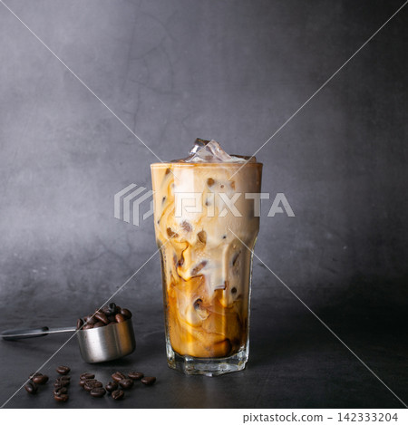 iced latte coffee into a transparent glass with ice. and roasted coffee beans on a black background studio photo iced latte coffee into a transparent glass with ice. and roasted coffee beans on a black background studio photo 142333204