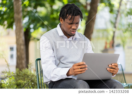 African American young man stressed by laptop news in city street park after online game loss defeat African American young man stressed by laptop news in city street park after online game loss defeat 142333208