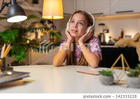 Teenager girl listens audiobook with wireless headphones focused smile surprise reacts to story joy Teenager girl listens audiobook with wireless headphones focused smile surprise reacts to story joy 142333228