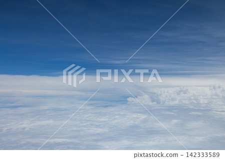 A beautiful sea of clouds and blue sky viewed from the airplane window. A beautiful sea of clouds and blue sky viewed from the airplane window. 142333589