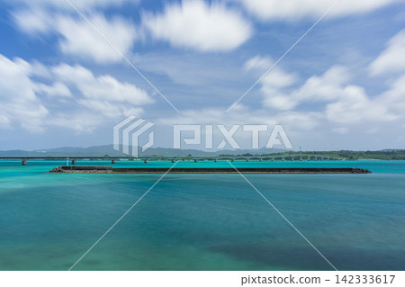 從日本沖繩縣眺望古里橋和矢賀地島,可以看到蔚藍的大海和海岸線。 從日本沖繩縣眺望古里橋和矢賀地島,可以看到蔚藍的大海和海岸線。 142333617