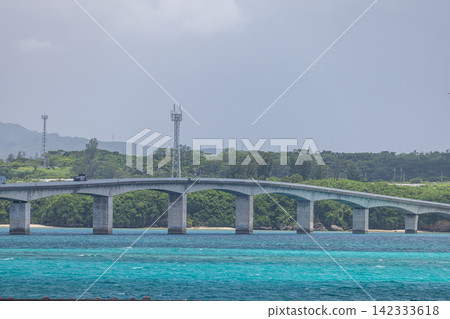 A view of the blue sea and coastline overlooking Kouri Bridge and Yagaji Island in Okinawa Prefecture, Japan. A view of the blue sea and coastline overlooking Kouri Bridge and Yagaji Island in Okinawa Prefecture, Japan. 142333618