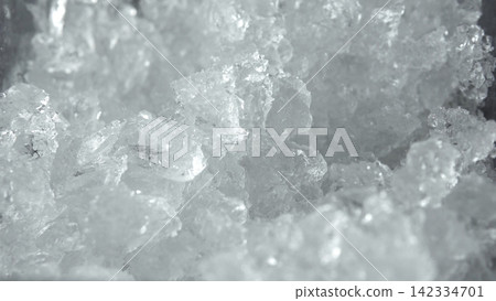 Crushed ice texture forming a refreshing frosty background, a natural winter element for cold drink concepts Crushed ice texture forming a refreshing frosty background, a natural winter element for cold drink concepts 142334701