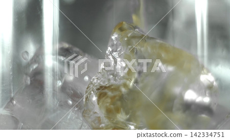 Ice cubes and liquid pouring creating splash splashes inside glass, clear refreshing beverage concept Ice cubes and liquid pouring creating splash splashes inside glass, clear refreshing beverage concept 142334751