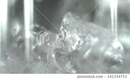 Abstract ice cube splashing in water, creating refreshing cold liquid movement and cool sensation Abstract ice cube splashing in water, creating refreshing cold liquid movement and cool sensation 142334753