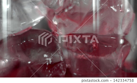Ice cubes melting in red beverage, cold refreshing drink close-up, liquid texture and abstract patterns Ice cubes melting in red beverage, cold refreshing drink close-up, liquid texture and abstract patterns 142334758