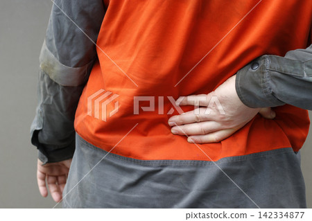 Man in work clothes with back pain Man in work clothes with back pain 142334877