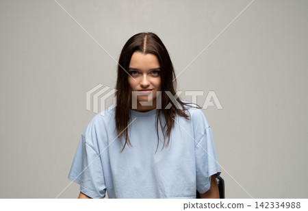 Confident brunette woman giving a subtle smirk, looking powerful and self-assured in studio portrait, expressing determination Confident brunette woman giving a subtle smirk, looking powerful and self-assured in studio portrait, expressing determination 142334988
