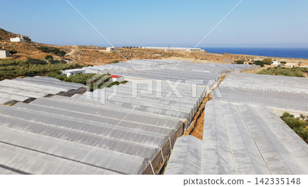 Extensive greenhouse farming operations in arid coastal landscape, Crete, Greece, providing agricultural production Extensive greenhouse farming operations in arid coastal landscape, Crete, Greece, providing agricultural production 142335148