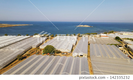 Greenhouses covering coastal landscape on island of Crete, demonstrating intensive agriculture near the Mediterranean Sea Greenhouses covering coastal landscape on island of Crete, demonstrating intensive agriculture near the Mediterranean Sea 142335232