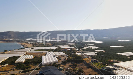 Aerial view of agriculture along the Falassarna coast in Crete, Greece, with extensive greenhouses and farming fields Aerial view of agriculture along the Falassarna coast in Crete, Greece, with extensive greenhouses and farming fields 142335233