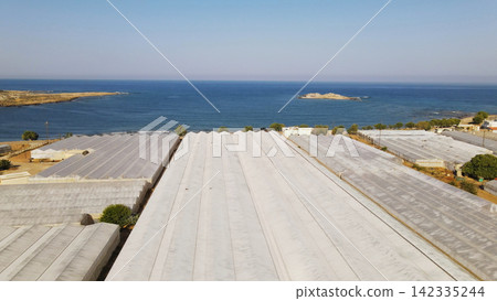 Greenhouses near the coastline in Crete, Greece showing agricultural land and the Mediterranean sea Greenhouses near the coastline in Crete, Greece showing agricultural land and the Mediterranean sea 142335244