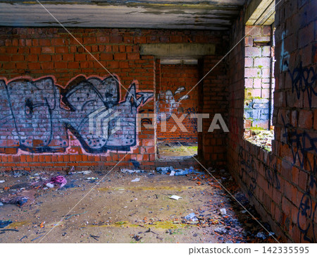 Interior of abandoned brick building with graffiti on walls and debris-strewn floor Interior of abandoned brick building with graffiti on walls and debris-strewn floor 142335595