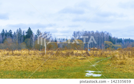 Abandoned rural soccer goal standing in overgrown meadow under cloudy sky, with soccer, goal, field, meadow detail Abandoned rural soccer goal standing in overgrown meadow under cloudy sky, with soccer, goal, field, meadow detail 142335659
