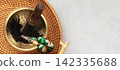 Tibetan Singing Bowl with Wooden Mallet and Beaded Bracelet on Woven Mat 142335688