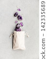 Amethyst Crystals in Cotton Pouch on Stone Background 142335689