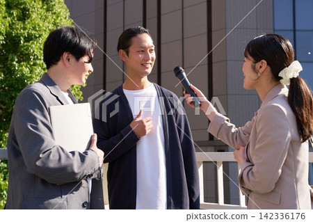 A woman conducting a street interview and a man answering her questions. A woman conducting a street interview and a man answering her questions. 142336176