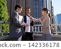 A female reporter holds a microphone to a male office worker who answers. 142336178